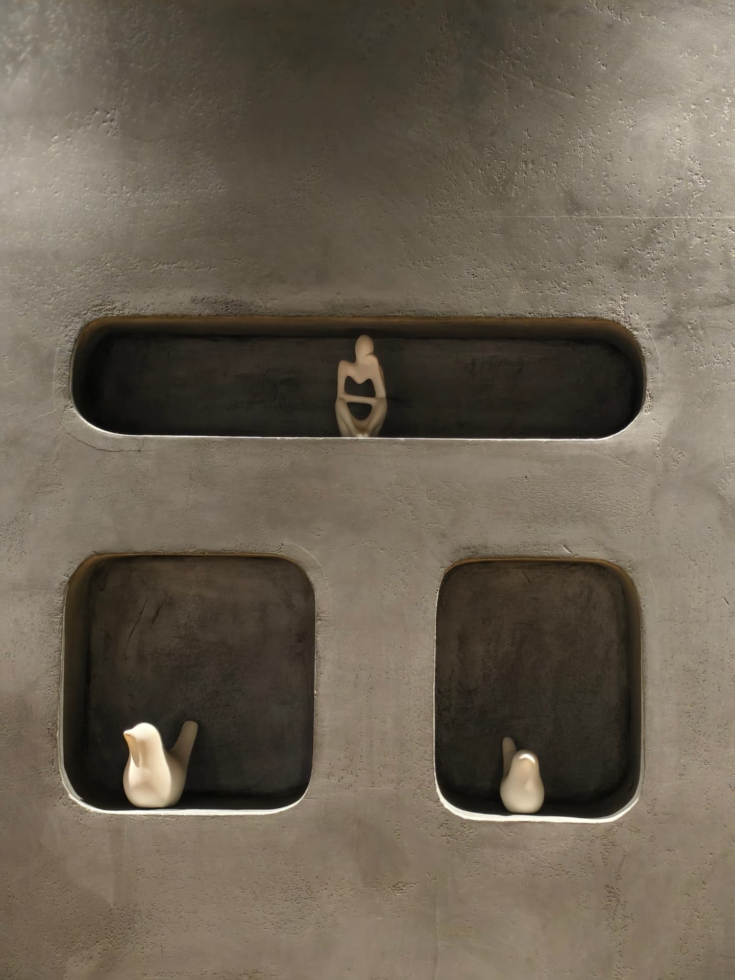 Ceramic birds resting in recessed wall niches at O’Co