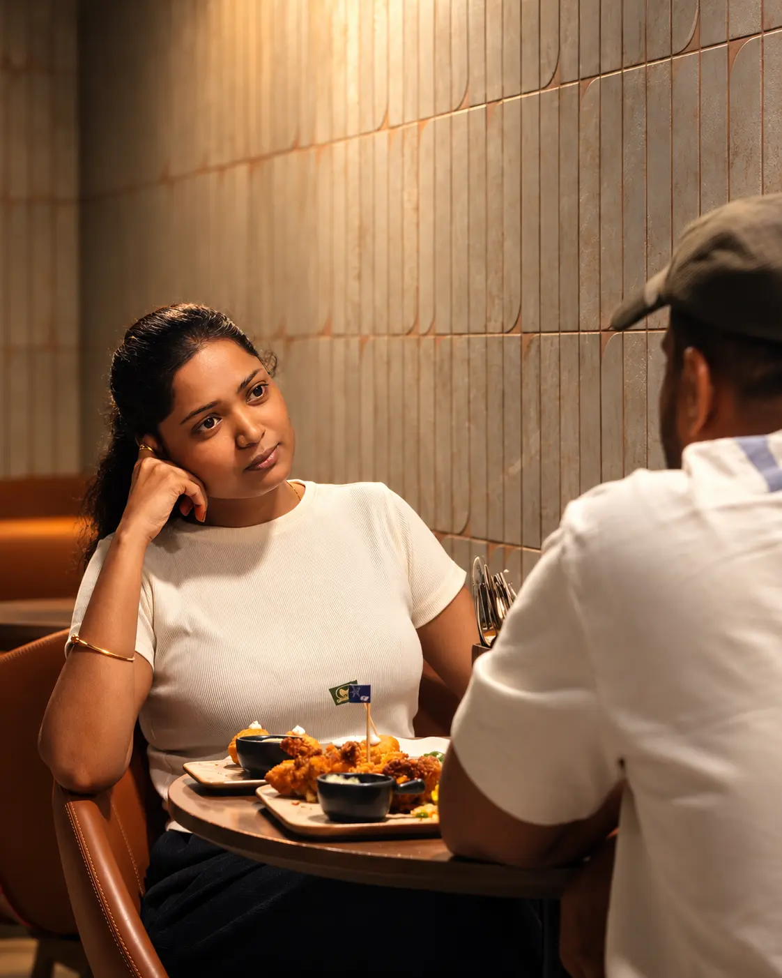 Two guests talking over shared plates at an O’Co table