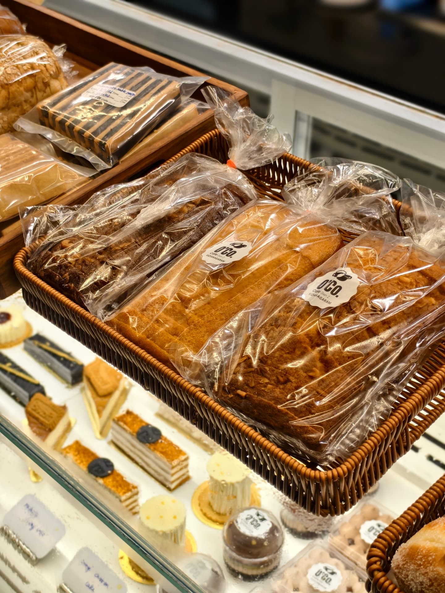 Packaged breads and pastries above O’Co’s dessert display